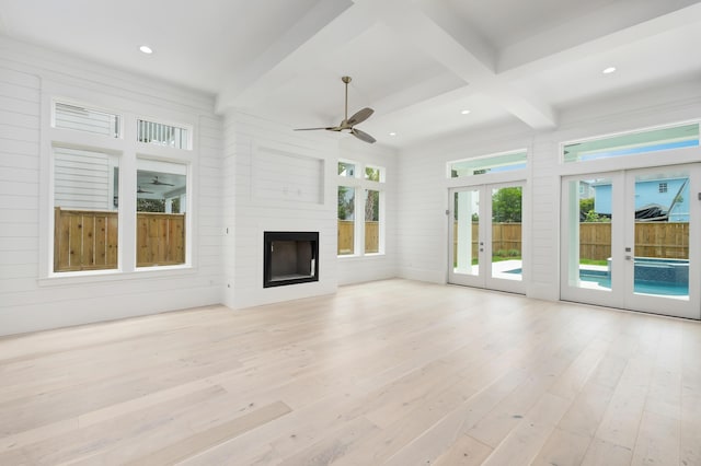 unfurnished living room featuring ceiling fan, beam ceiling, light hardwood / wood-style flooring, and french doors