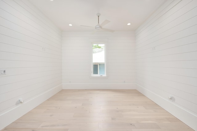 unfurnished room featuring wood walls and light hardwood / wood-style flooring