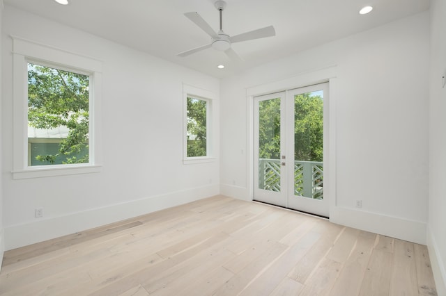 empty room featuring a wealth of natural light, french doors, ceiling fan, and light hardwood / wood-style floors