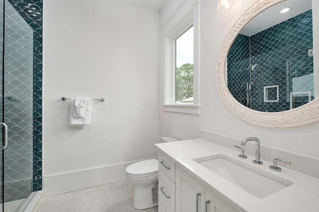 bathroom featuring a tile shower, vanity, toilet, and tile patterned floors