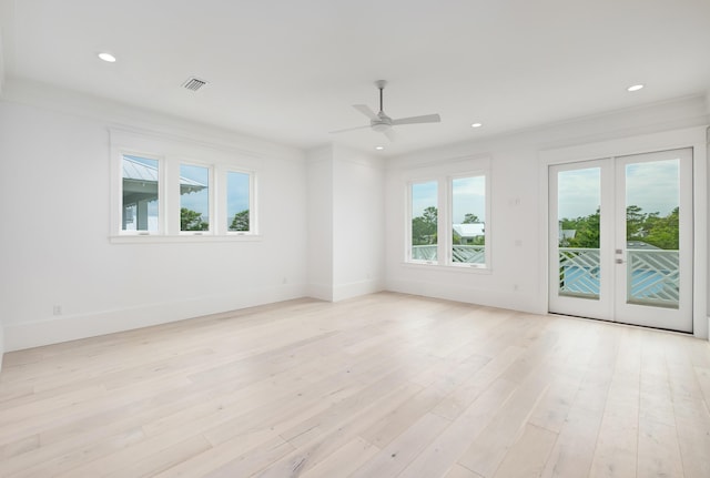 unfurnished room with light wood-type flooring, crown molding, a wealth of natural light, and french doors