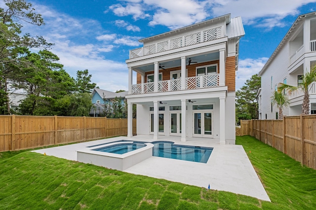 back of house featuring ceiling fan, french doors, a balcony, a patio area, and a swimming pool with hot tub