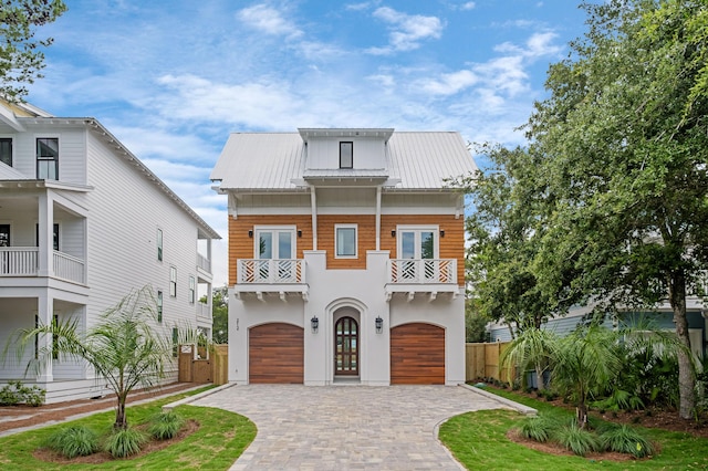 view of front of property with french doors, a balcony, and a garage