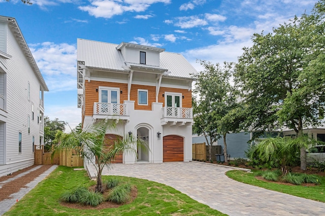 view of front of home featuring a garage, a balcony, and french doors