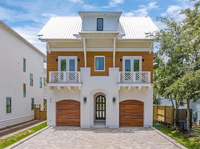 view of front facade featuring french doors, a balcony, and a garage