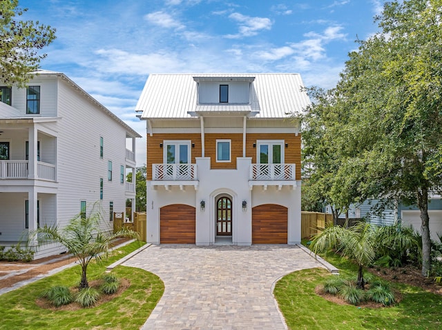 view of front of house with a garage, a balcony, and french doors