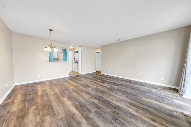 unfurnished living room featuring dark wood-type flooring and a chandelier