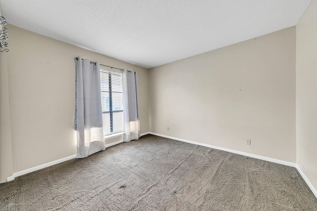 carpeted empty room featuring a textured ceiling