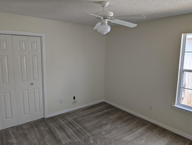 unfurnished bedroom featuring baseboards, a closet, a textured ceiling, ceiling fan, and carpet
