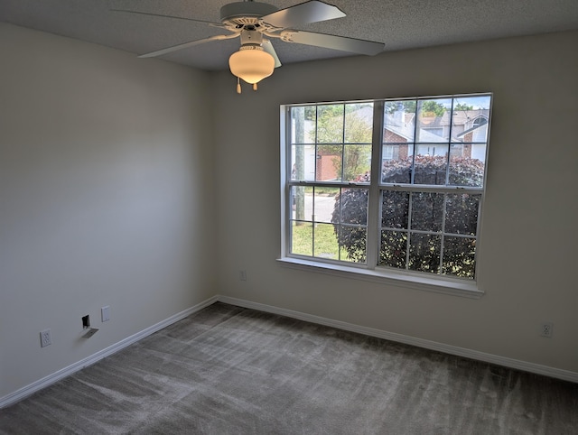 carpeted spare room with baseboards, a ceiling fan, and plenty of natural light
