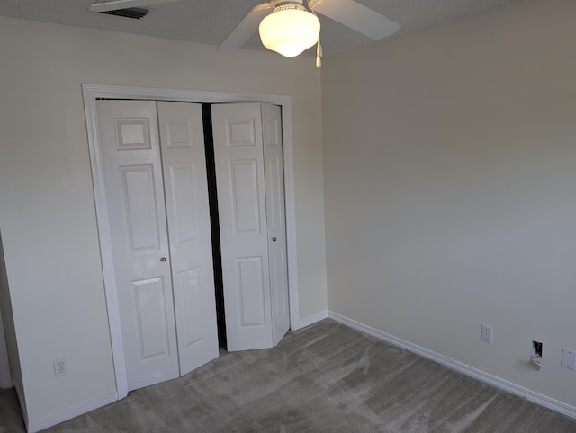 unfurnished bedroom with ceiling fan, a closet, visible vents, carpet flooring, and baseboards