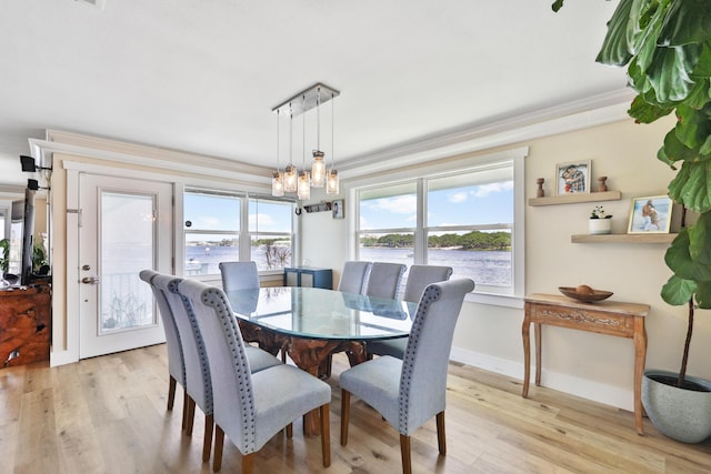 dining space with light hardwood / wood-style flooring, a chandelier, and ornamental molding