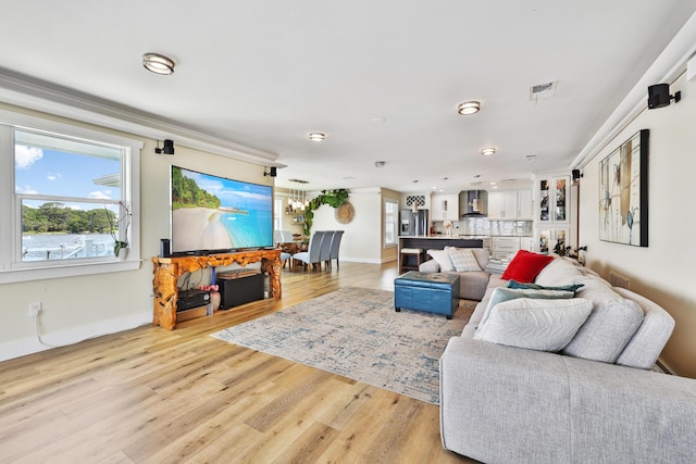 living room featuring light hardwood / wood-style flooring and crown molding