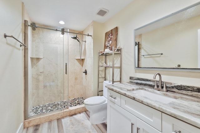 bathroom with vanity, wood-type flooring, an enclosed shower, and toilet