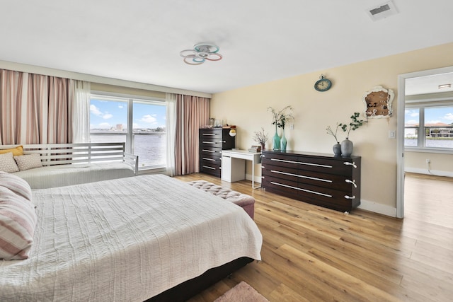 bedroom with light wood-type flooring and multiple windows