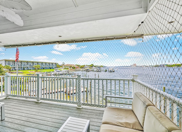 deck featuring ceiling fan and a water view