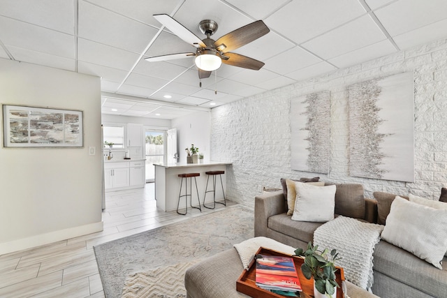 living room with a paneled ceiling and ceiling fan