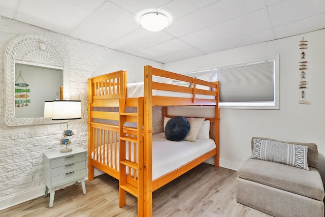 bedroom featuring a drop ceiling and hardwood / wood-style flooring