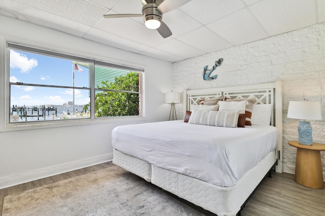 bedroom featuring a paneled ceiling, ceiling fan, and hardwood / wood-style floors