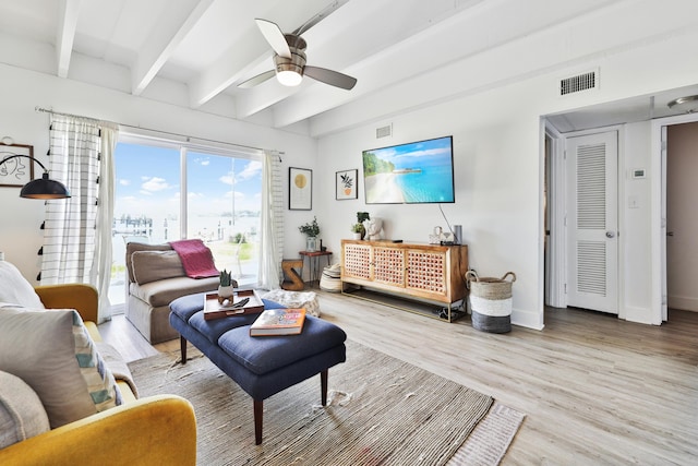 living room featuring ceiling fan, beam ceiling, and light wood-type flooring