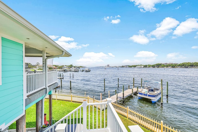 view of dock featuring a lawn and a water view