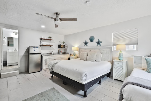 bedroom with ceiling fan, stainless steel fridge, ensuite bathroom, a textured ceiling, and light tile patterned floors