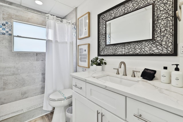 bathroom with hardwood / wood-style flooring, toilet, vanity, and walk in shower