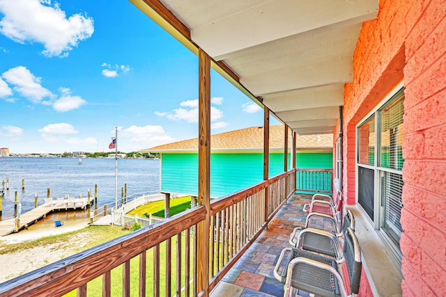 balcony with a water view and a dock