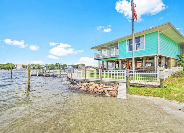 view of dock with a balcony and a water view