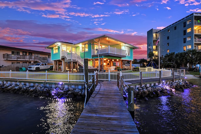 dock area with a balcony and a water view