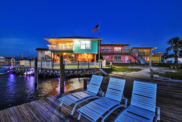 dock area with a water view and a balcony