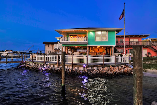 back house at dusk with a water view