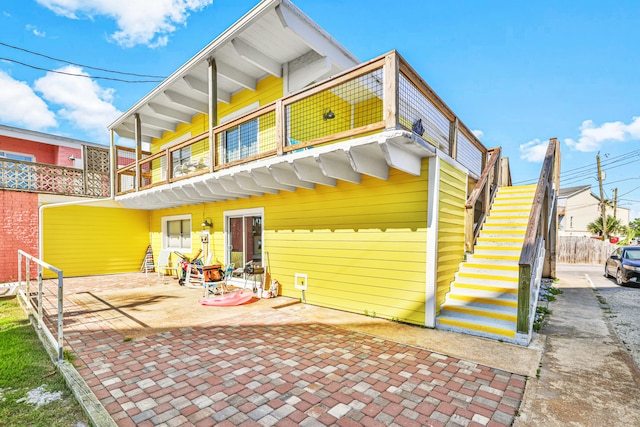 back of house featuring a patio area and a balcony