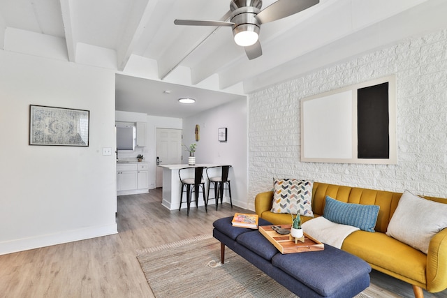 living room with beam ceiling, light hardwood / wood-style flooring, and ceiling fan