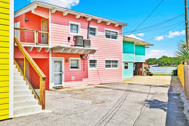 view of front of house featuring central AC and a water view