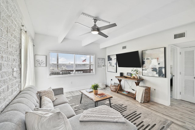 living room with hardwood / wood-style flooring, ceiling fan, and beam ceiling