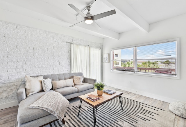 living room with ceiling fan, beamed ceiling, and hardwood / wood-style flooring