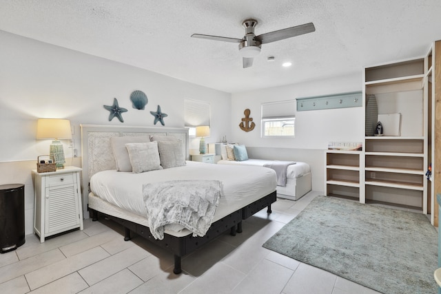 bedroom featuring a textured ceiling, ceiling fan, and light tile patterned flooring