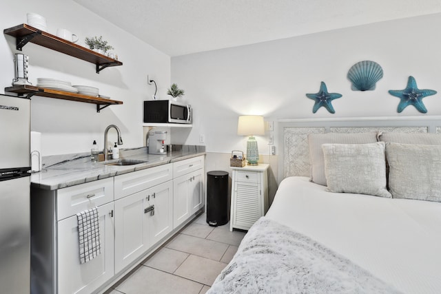 bedroom featuring light tile patterned floors, sink, and stainless steel refrigerator