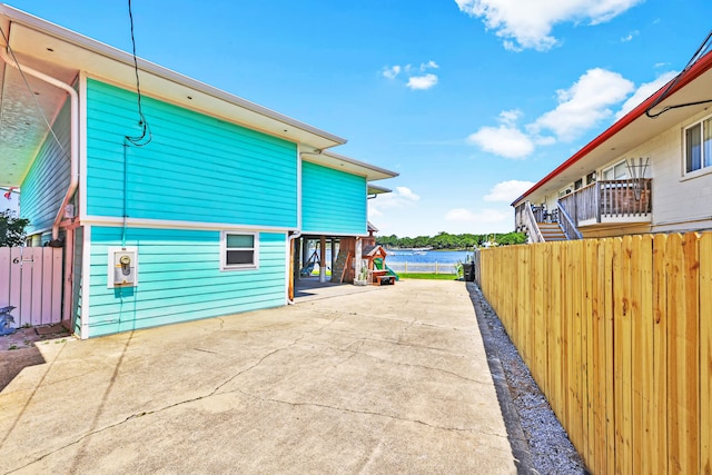 view of side of home with a carport and a water view