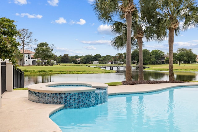 view of swimming pool with an in ground hot tub and a water view