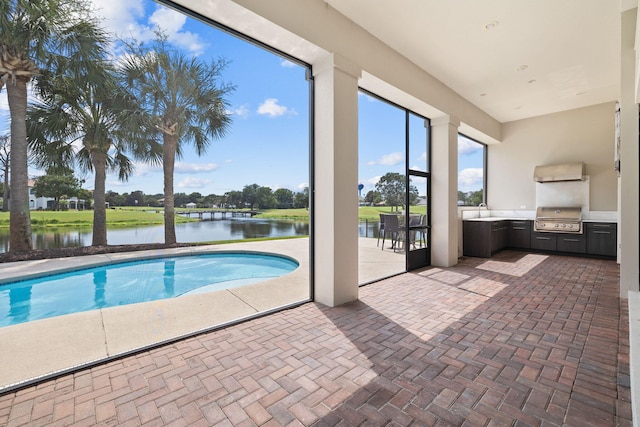 view of swimming pool with a water view, sink, and grilling area