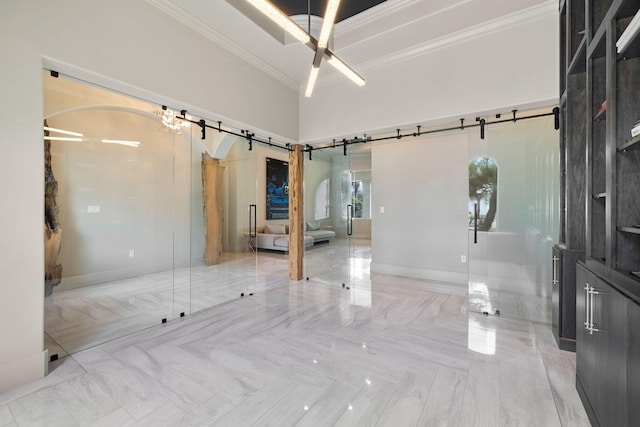 empty room featuring crown molding and a barn door