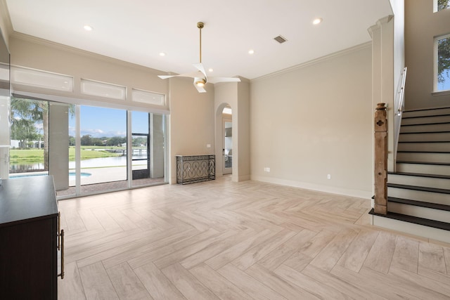 unfurnished living room featuring a water view, light parquet flooring, and crown molding