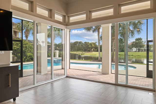 doorway to outside with a water view and light parquet flooring