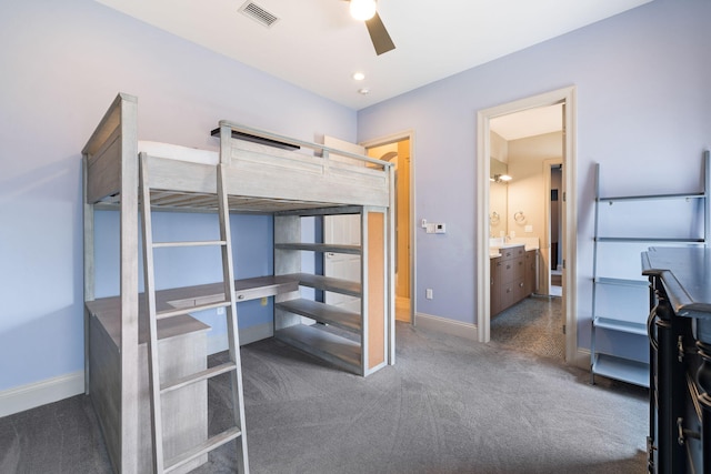 bedroom with connected bathroom, ceiling fan, and dark colored carpet