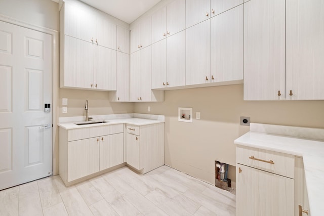 laundry room featuring cabinets, electric dryer hookup, sink, and washer hookup