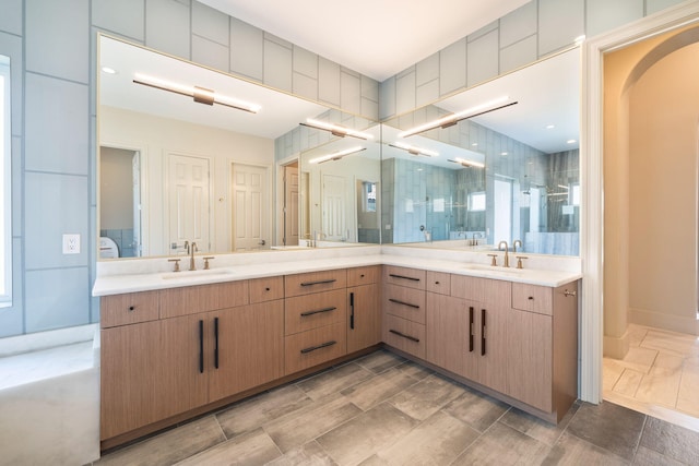 bathroom featuring a shower with door and vanity