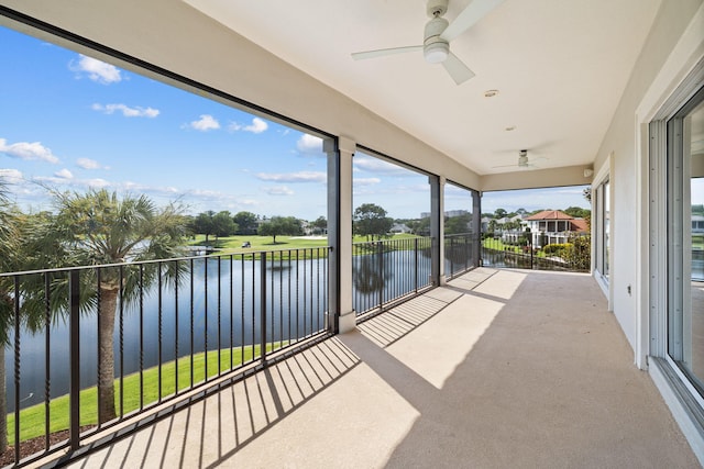 unfurnished sunroom featuring a water view and ceiling fan