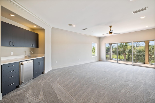 interior space with ceiling fan, ornamental molding, light colored carpet, and indoor wet bar